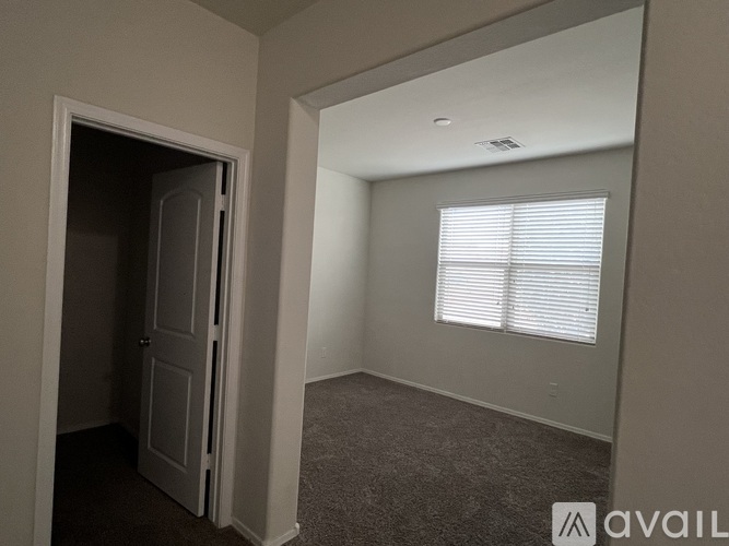 A room with a door and a window with blinds.