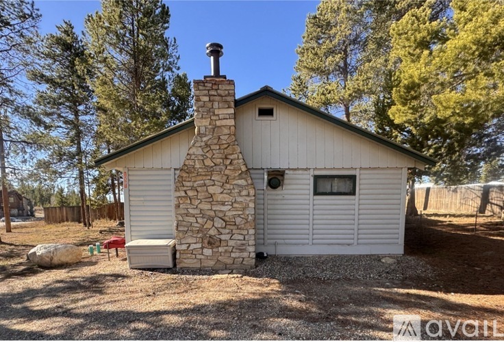 A house with a stone chimney is for sale.