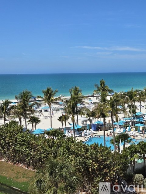 A beach with palm trees and a pool.