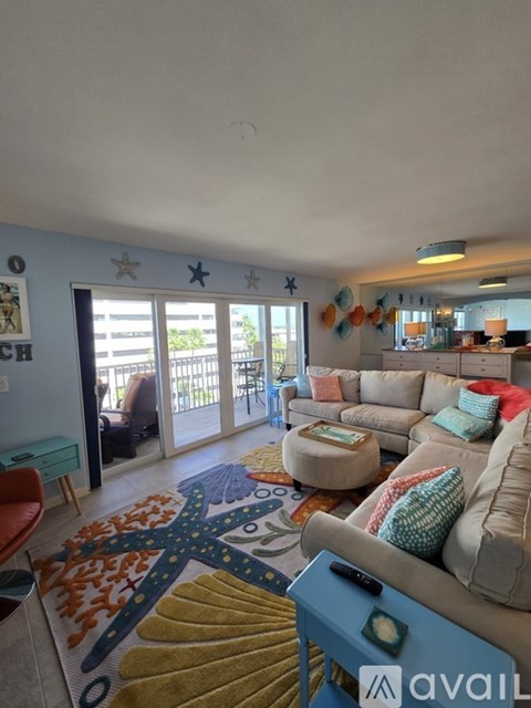 A living room with a couch, a chair, and a rug with a tree design.