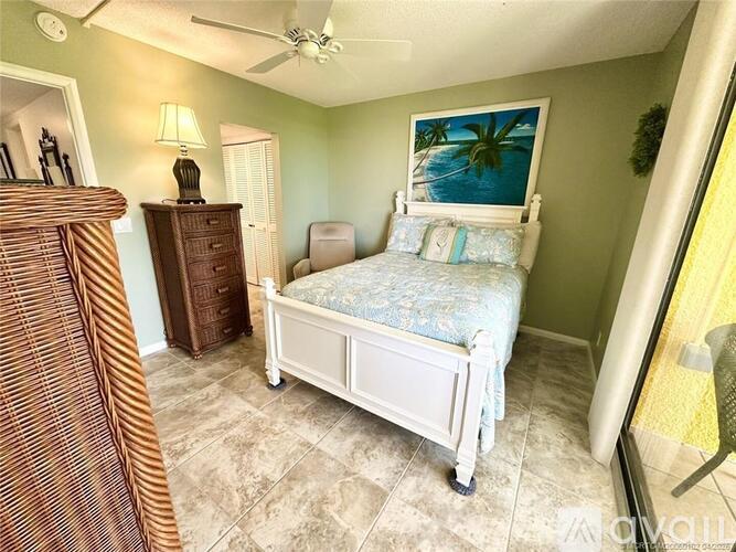 A bedroom with a bed, dresser, and chair.
