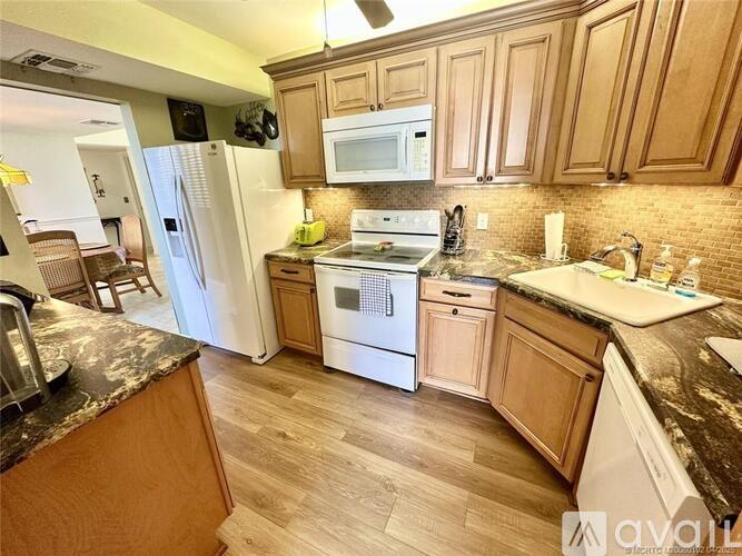 A kitchen with wooden cabinets and a white refrigerator.