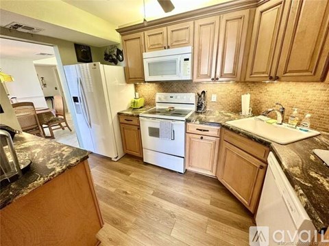A kitchen with wooden cabinets and a white refrigerator.
