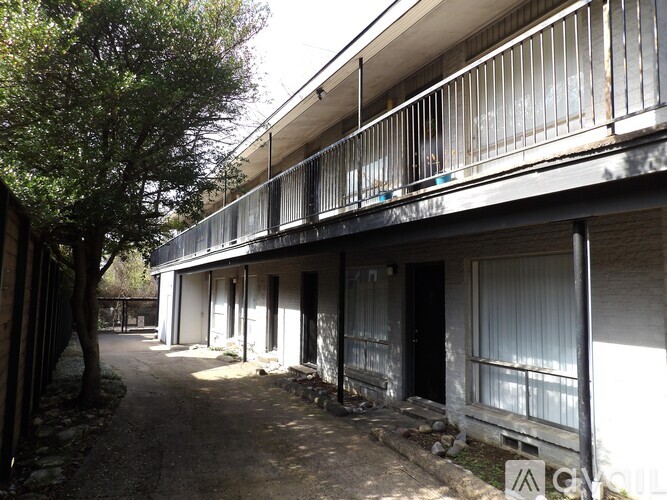 A balcony of a building with a tree on the left.