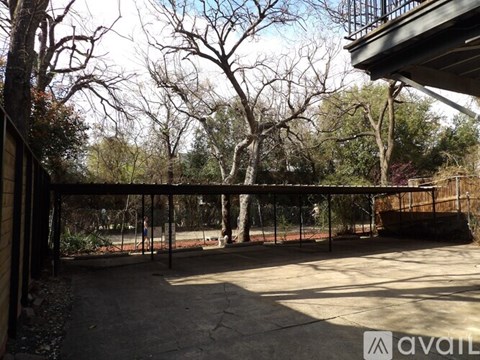A backyard with a fence and trees.