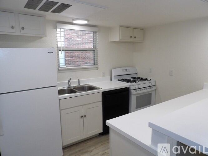 A kitchen with white appliances and cabinets.