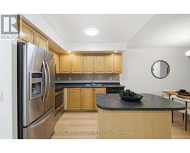 A modern kitchen with wooden cabinets and a stainless steel refrigerator.