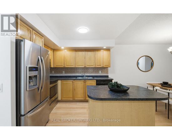A modern kitchen with wooden cabinets and a stainless steel refrigerator.