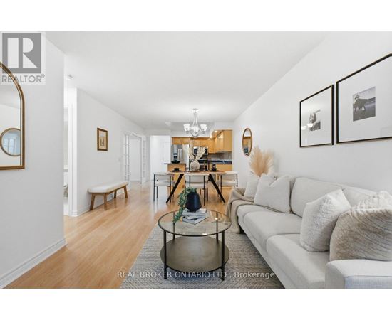 A living room with a white couch and a glass coffee table.