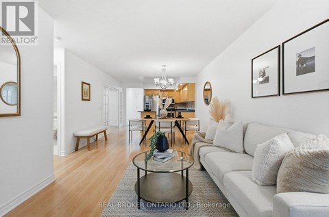 A living room with a white couch and a glass coffee table.