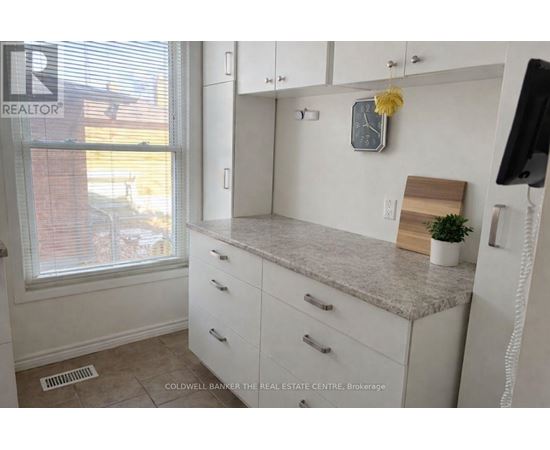 A kitchen with white cabinets and a granite countertop.