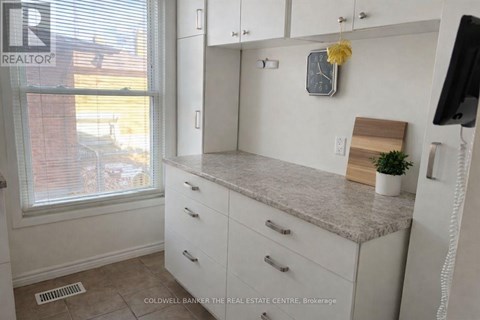A kitchen with white cabinets and a granite countertop.