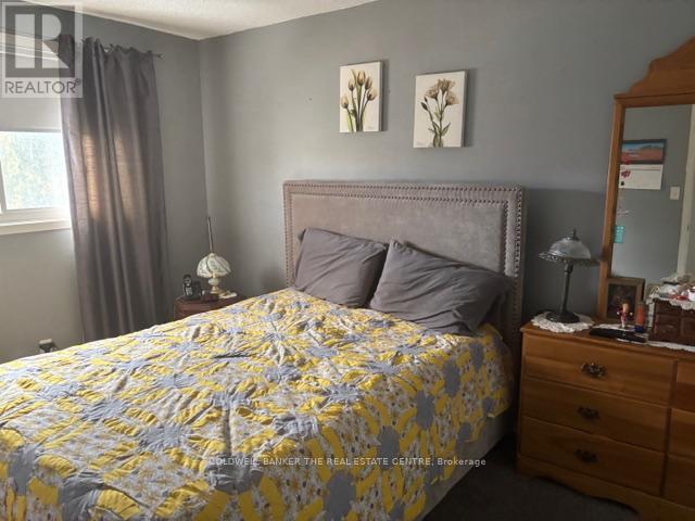 A bedroom with a bed, nightstand, and lamp.