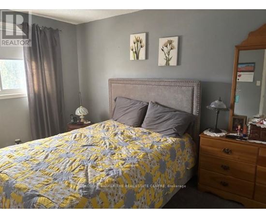 A bedroom with a bed, nightstand, and lamp.