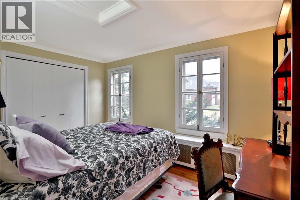 A bedroom with a bed, a chair, and a window.