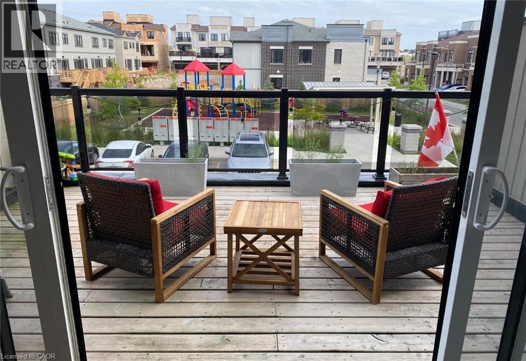 A balcony with two chairs and a table overlooking a playground.