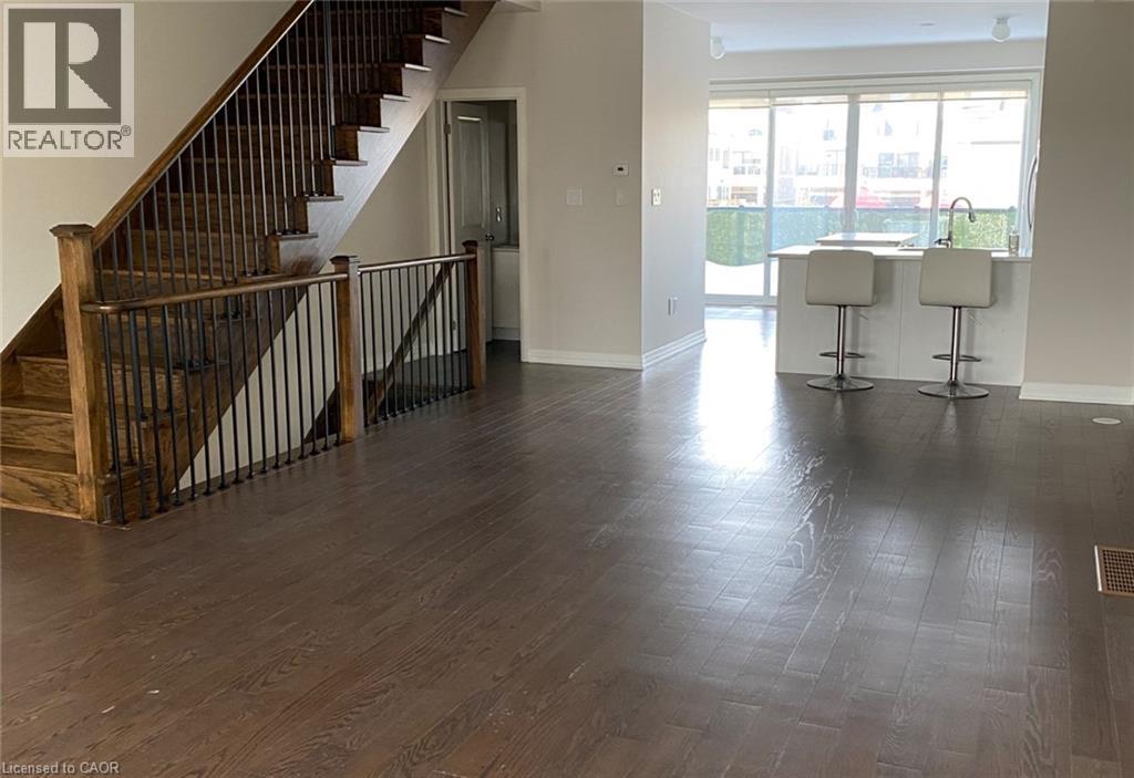 A living room with a staircase and bar stools.