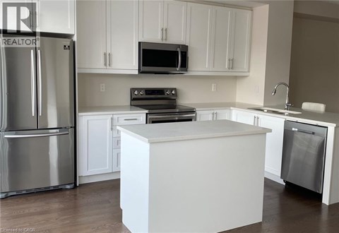 A kitchen with white cabinets and a white island.