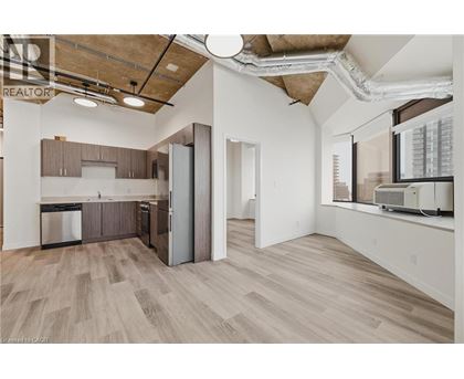 A kitchen with wooden floors and a large window.