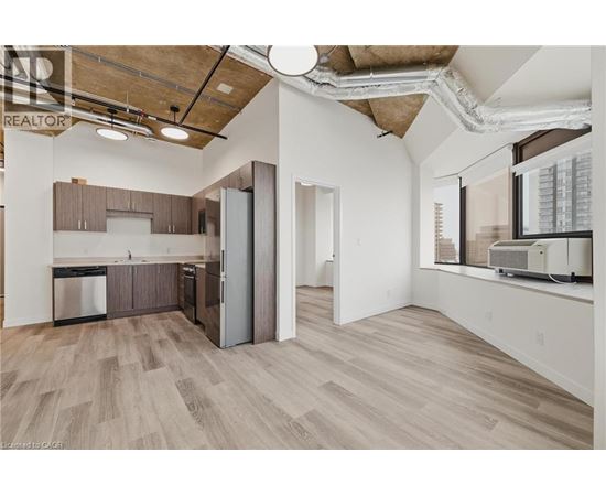 A kitchen with wooden floors and a large window.