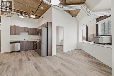 A kitchen with wooden floors and a large window.