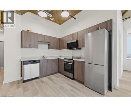 A kitchen with a refrigerator, oven, and microwave.