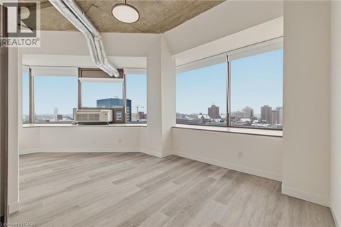 A spacious room with a view of the cityscape through large windows.