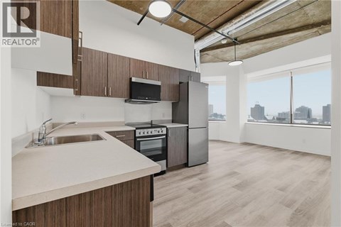 A kitchen with wooden cabinets and a stainless steel oven.