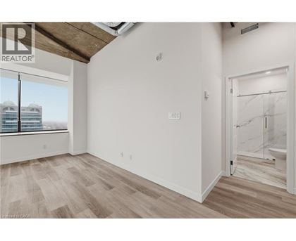 A room with a window overlooking a building with the logo REALTOR on the top left.