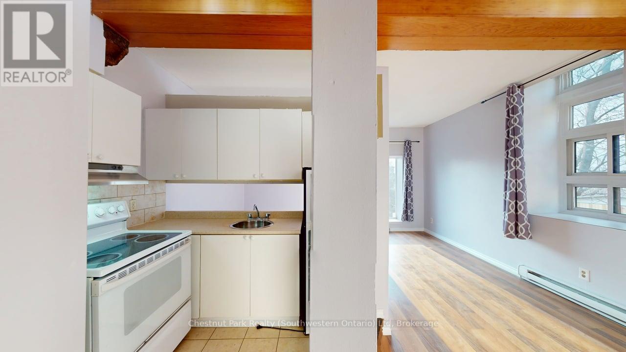 A kitchen with white cabinets and a stove top oven.
