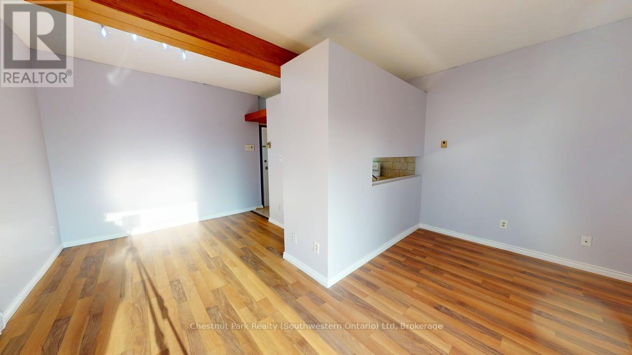 A room with wooden flooring and white walls.