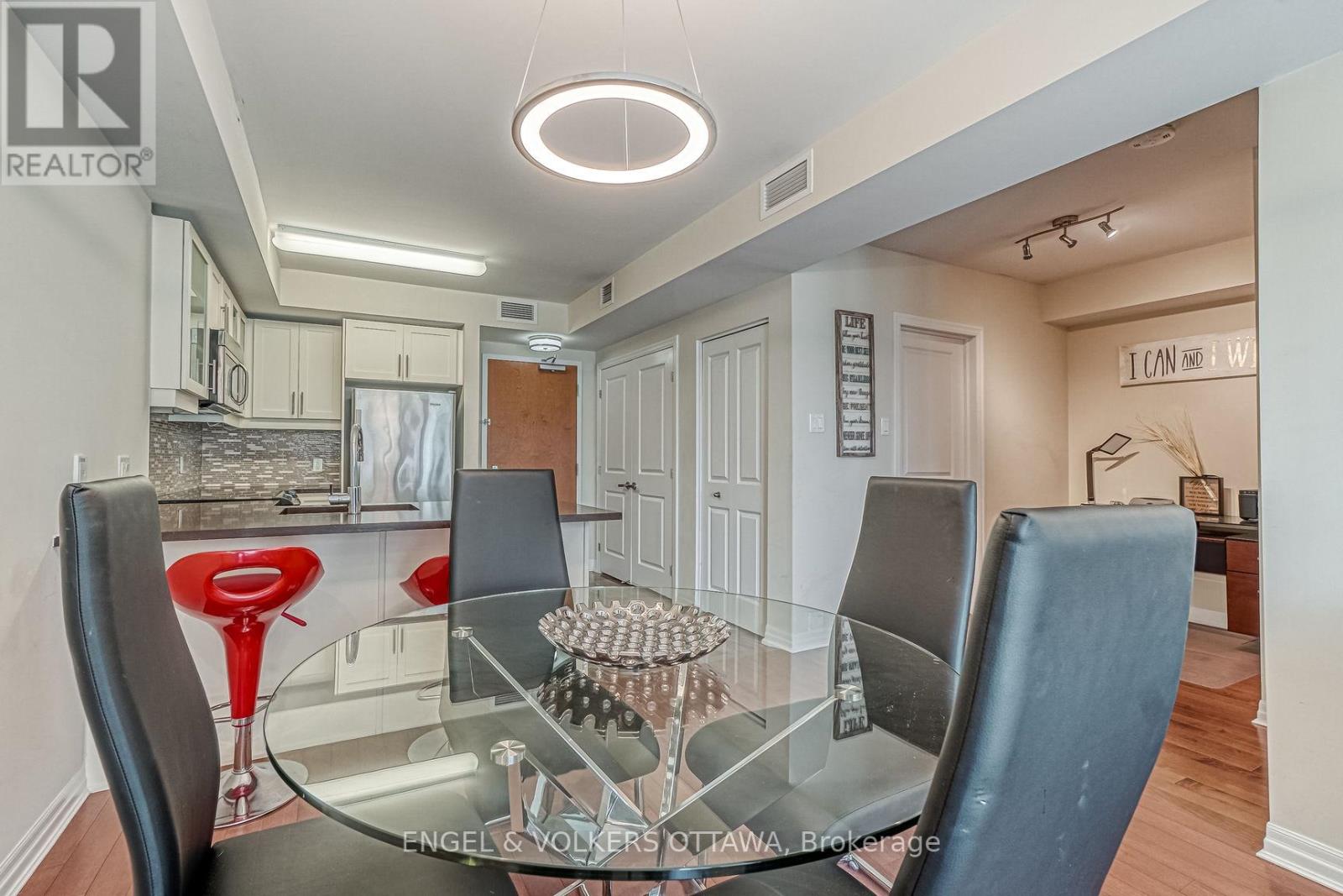 A modern dining room with a glass table and chairs.