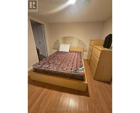 A bedroom with a bed, nightstand, and a dresser.