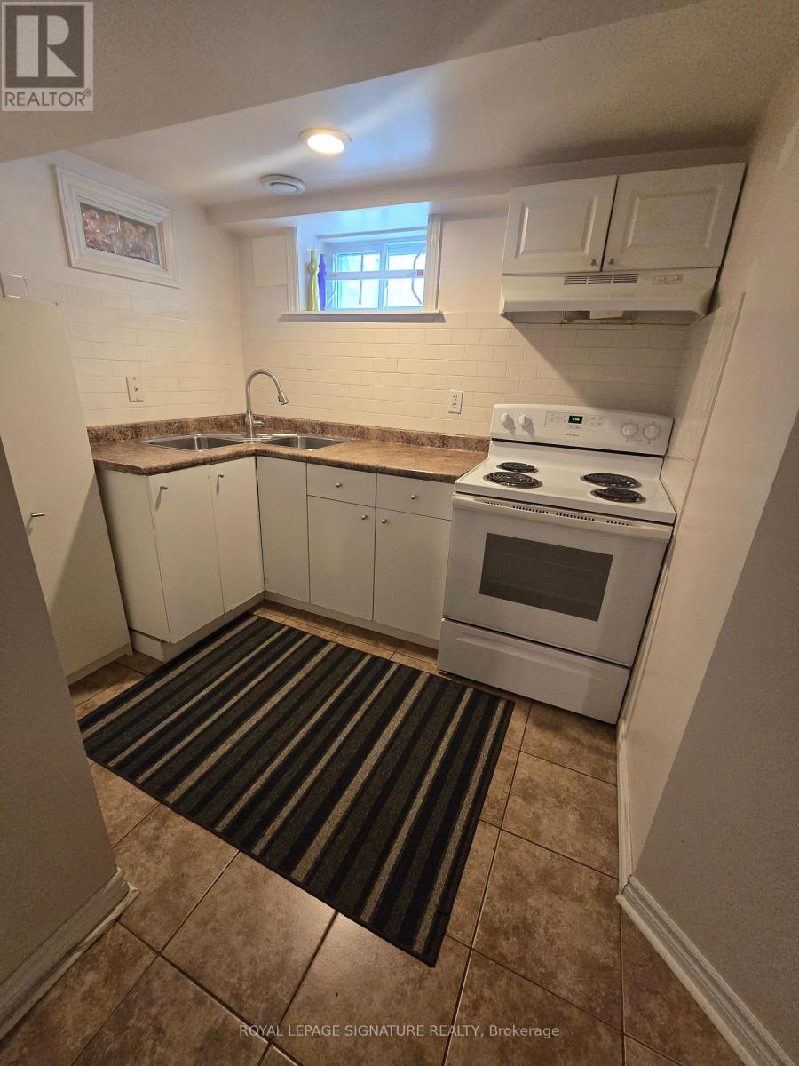 A small kitchen with a white stove and cabinets.