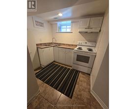 A small kitchen with a white stove and cabinets.