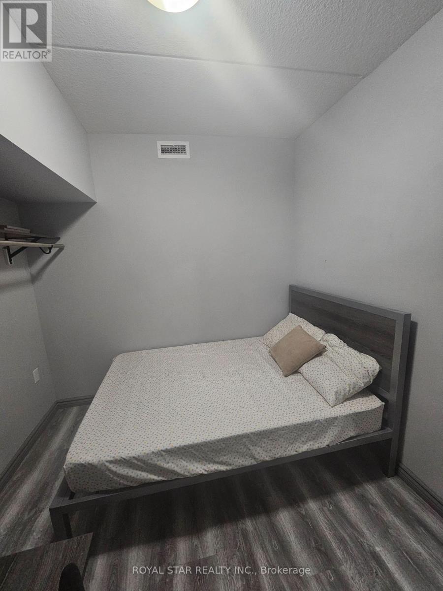 A bedroom with a bed, pillows, and a wooden headboard.