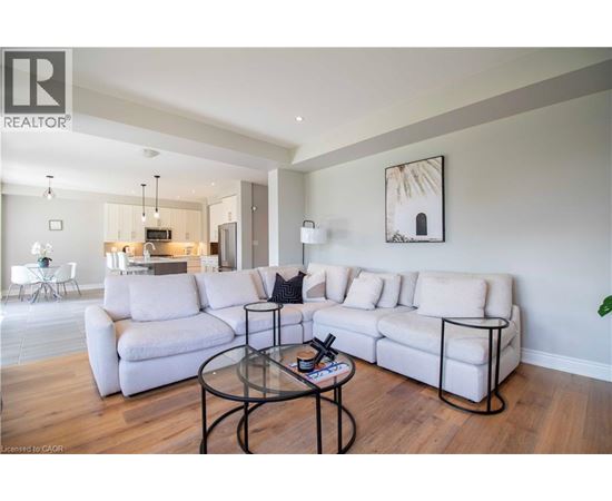 A living room with a white couch and a glass coffee table.