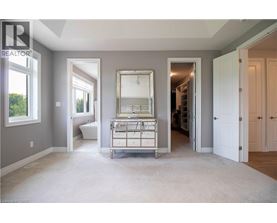A well-lit, spacious room with a large mirror and a built-in cabinet.