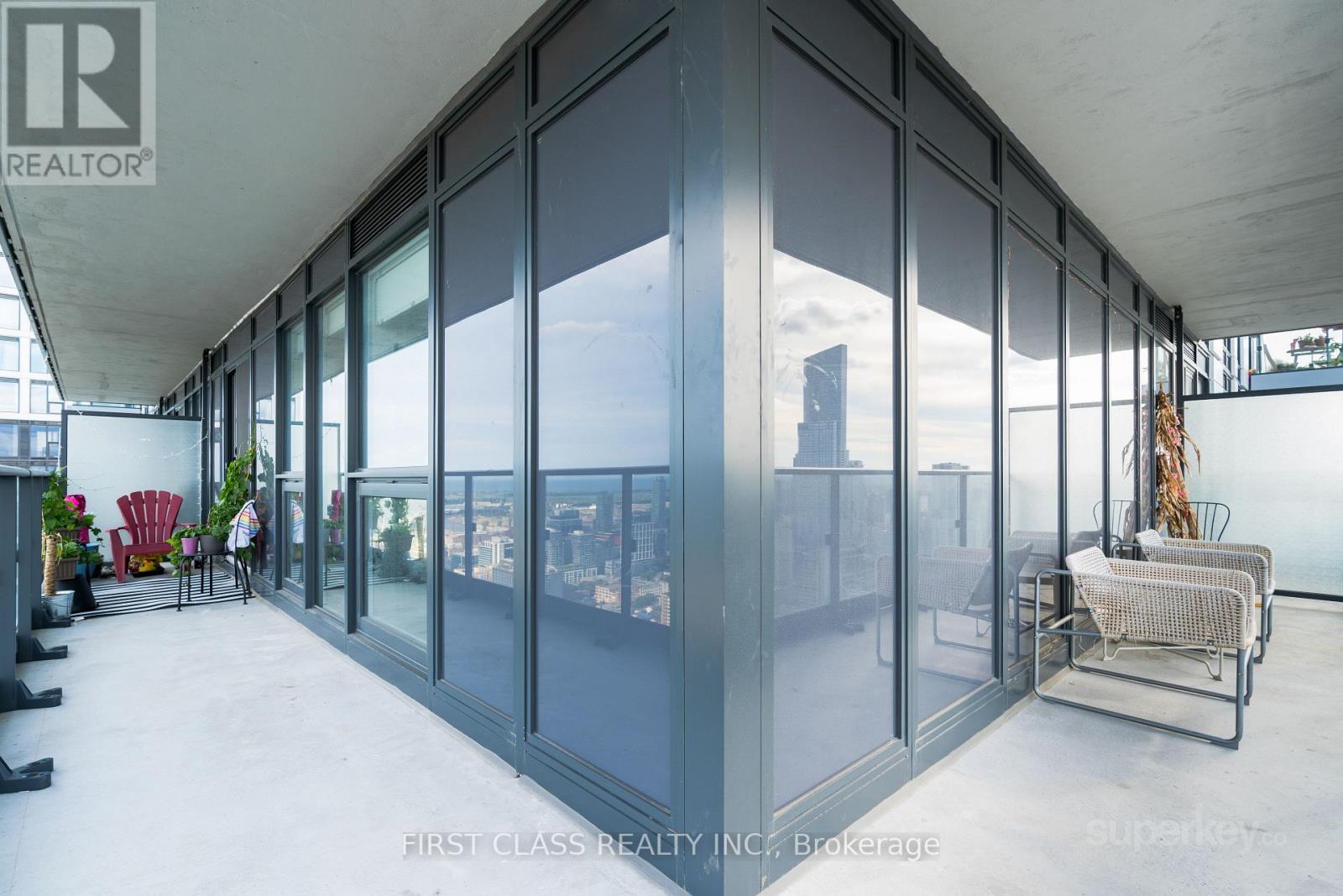 A balcony with glass walls and a chair.