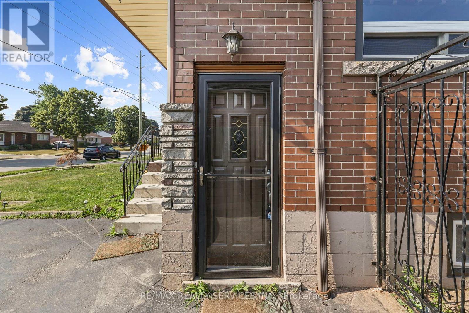 A house with a black door and a brick wall.