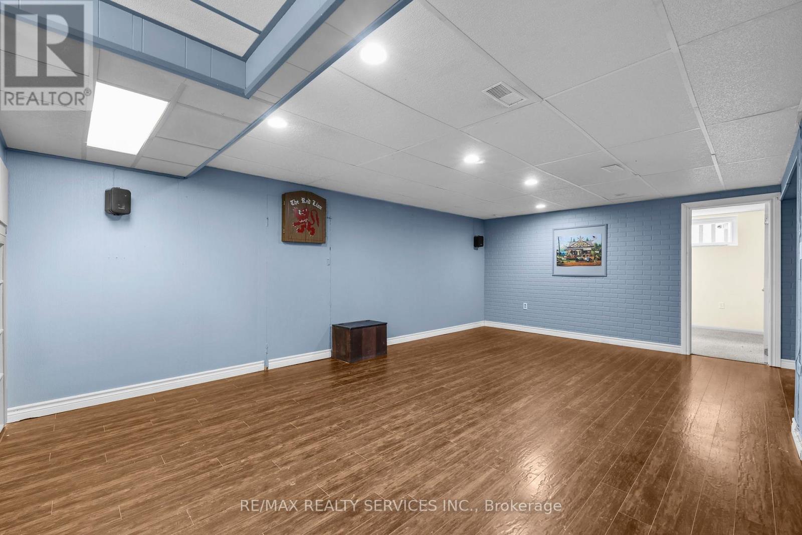 A room with wooden flooring and a painting on the wall.