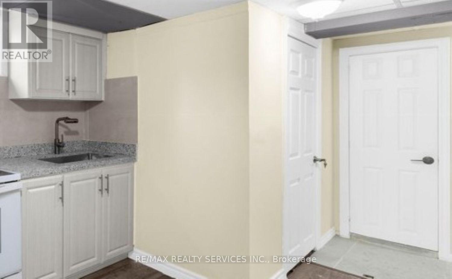 A kitchen with white cabinets and a sink.