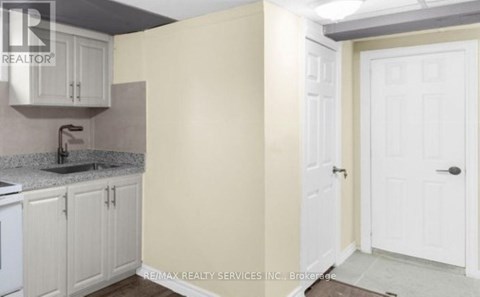 A kitchen with white cabinets and a sink.