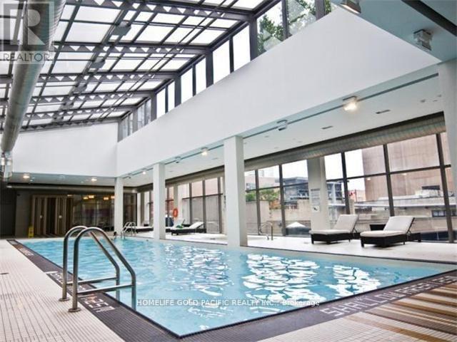 A large indoor swimming pool with a glass ceiling.