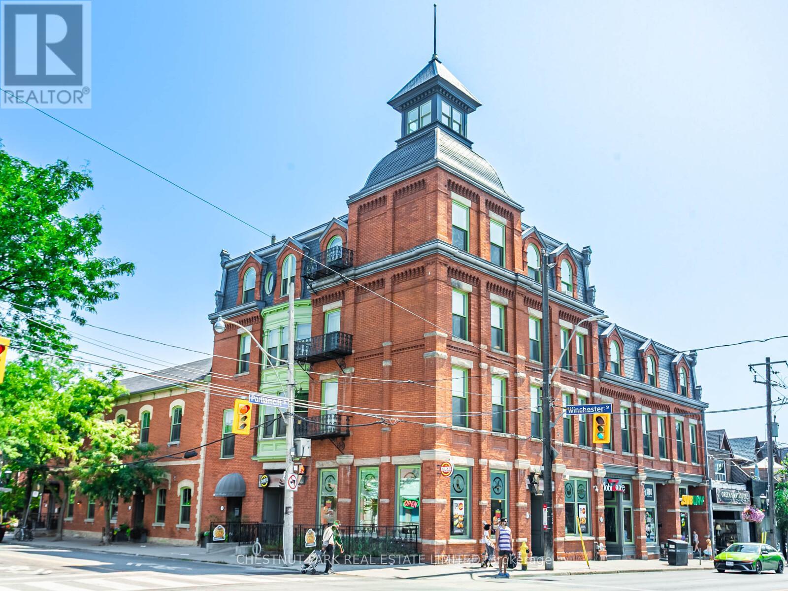 A large red brick building with a clock tower on the corner.