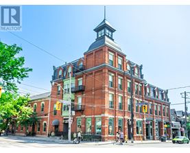 A large red brick building with a clock tower on the corner.