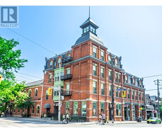 A large red brick building with a clock tower on the corner.