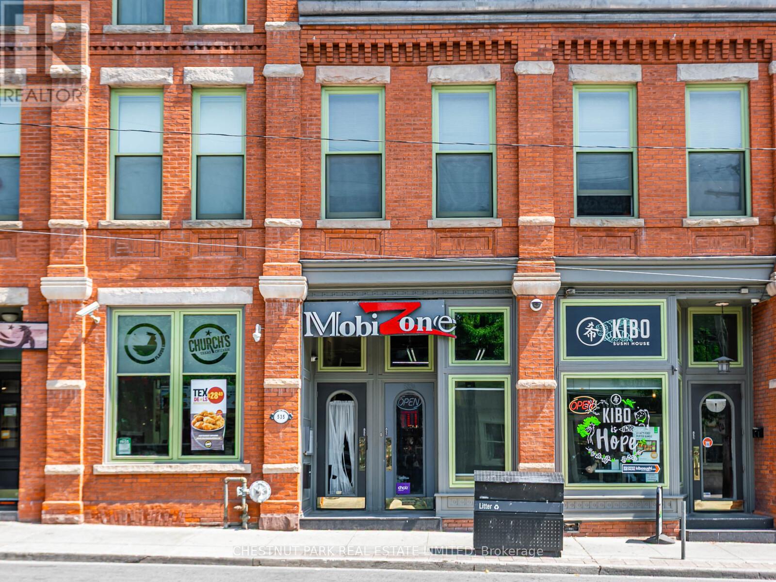 A red brick building with a Mobil One gas station on the ground floor.