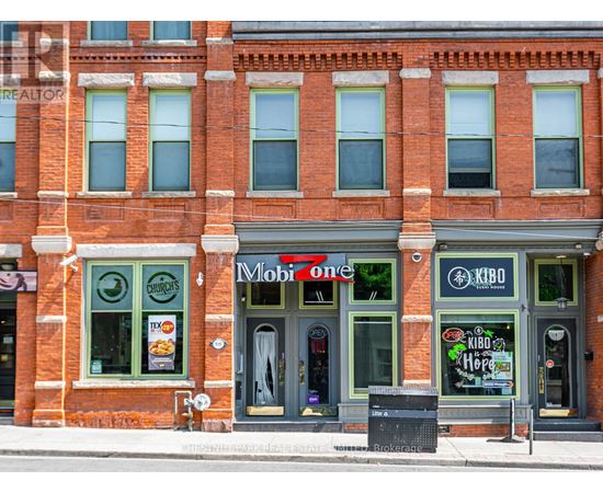 A red brick building with a Mobil One gas station on the ground floor.