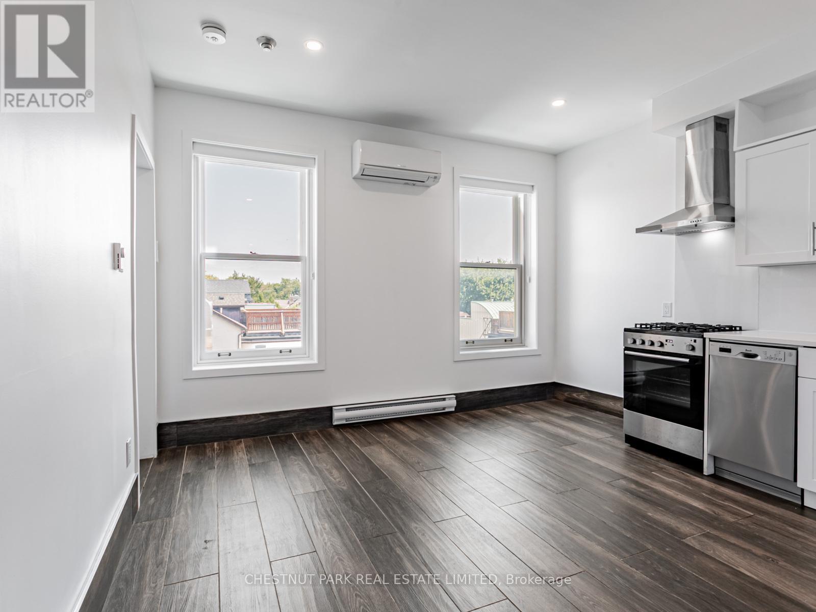 A well-lit kitchen with a stove top oven and a window.